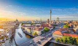 Panorama über Berlin während einer Rundreise durch das schöne Mitteleuropa: Spree und Berliner Fernsehturm im Hintergrund bei Sonnenuntergang