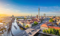 Panorama über Berlin während einer Rundreise durch das schöne Mitteleuropa: Spree und Berliner Fernsehturm im Hintergrund bei Sonnenuntergang