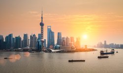 Skyline Shangais: Blick vom Hafen bei Sonnenuntergang, im Hintergrund Hochhäuser der chinesichen Metropole
