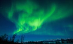 Reise durch den Norden Europas: Nordlicht (Aurora Borealis) gesehen in Lappland auf einer Rundreise durch / Skandinavien