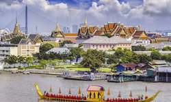 Königspalast in Thailands Hauptstadt Bangkok. Auf dem Fluss ein goldenes Schiff der königlichen LEibgarde