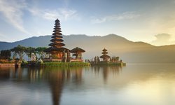 Rundreise auf Bali, der hinduistischen Insel Indonesiens: Trauhafter Blick auf den Tempel Pura Ulun Danu, der sich bei Sonnenaufgang im See spiegelt